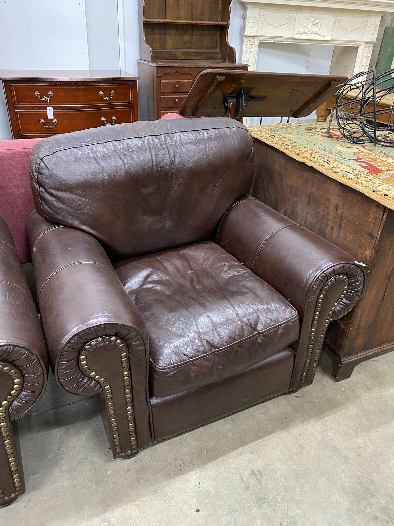 A pair of contemporary studded brown leather armchairs, width 98cm, depth 84cm, height 80cm